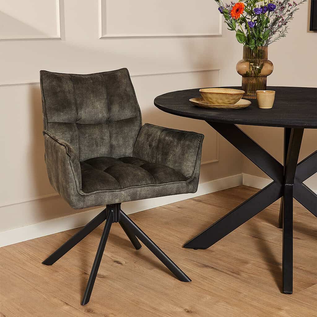 Houten eetkamertafel met vintage stoelen en decoratieve bloemen in een stijlvolle interieuromgeving.