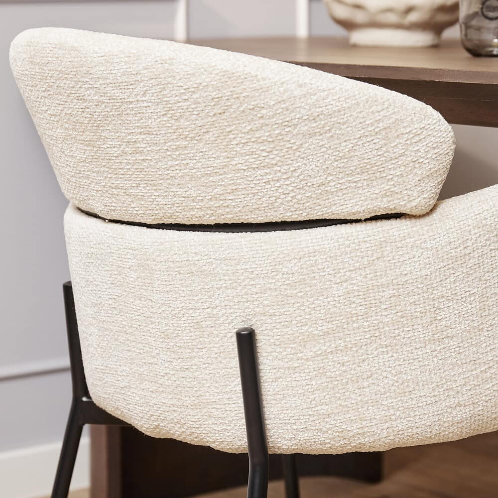 Elegant divan met zachte, geborduurde bekleding en zwart metalen poten, perfect voor een modern interieur en comfortabele zithoek.
