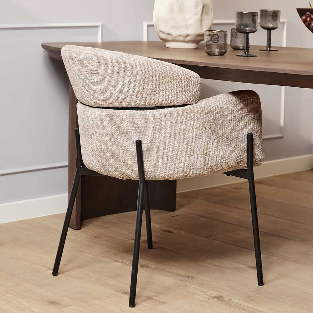 Stijlvolle beige eetkamerstoel met zachte bekleding en zwart metalen poten, perfect voor een modern interieur.