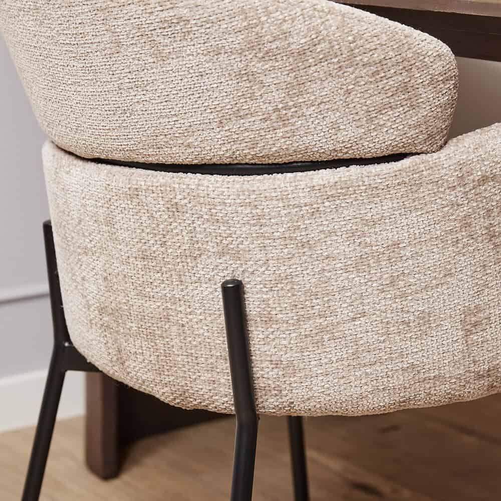 Zwarte metalen poten bij een beige stoffen stoel, modern design van Mokana Meubelen voor stijlvolle Interieur decoratie.