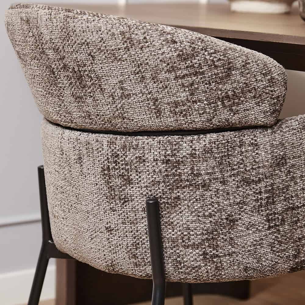 Harlekijn gestoffeerde eetkamerstoel met moderne zwarte metalen poten, perfect voor een stijlvolle en comfortabele eetruimte.