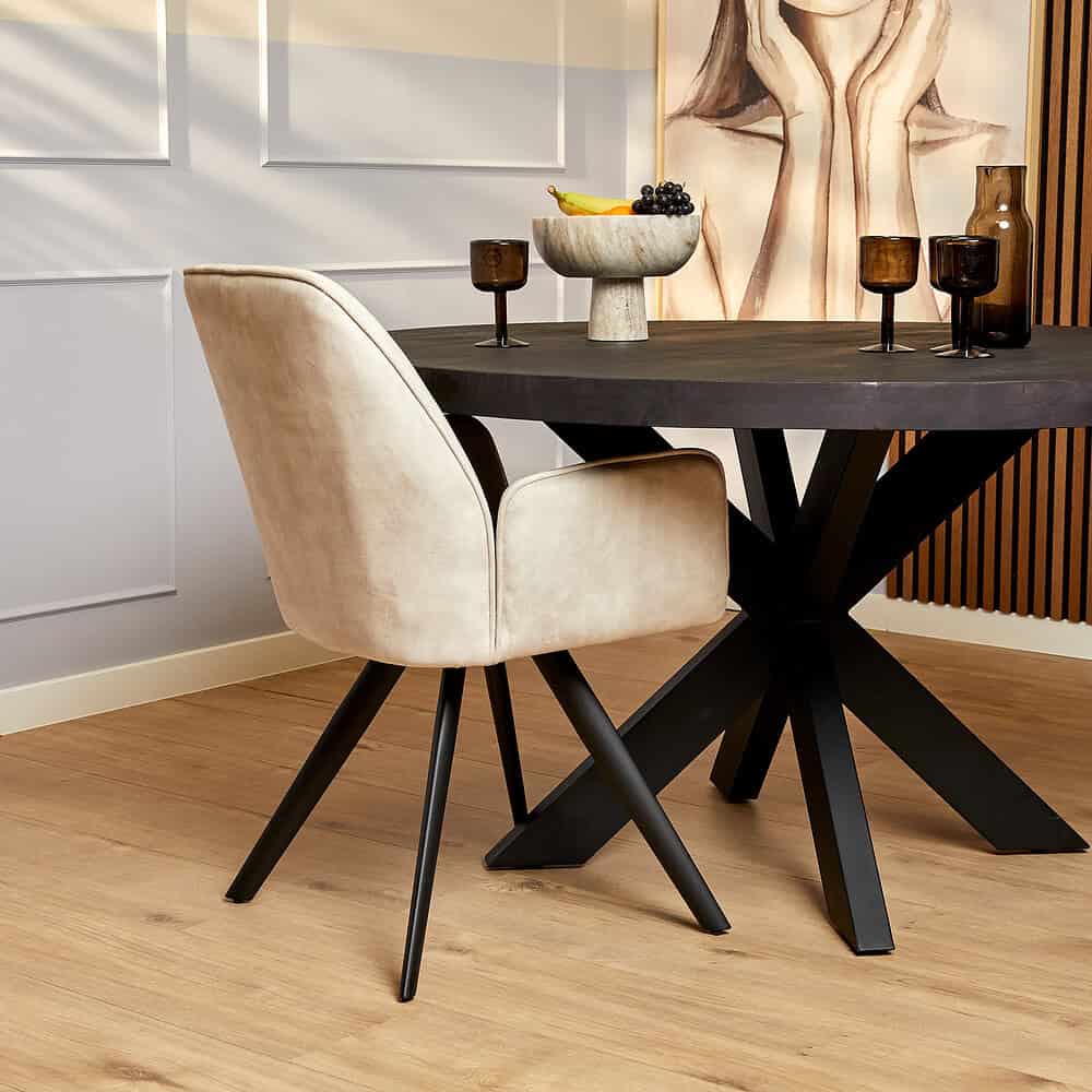 Modern eettafel met zwart houten blad en unieke X-vormige basis in een stijlvolle eetkamer.