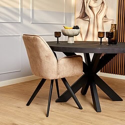 Moderne eetkamerstoel met beige suède bekleding en zwarte houten poten, passend bij houten eettafel, in stijlvolle interieursetting.