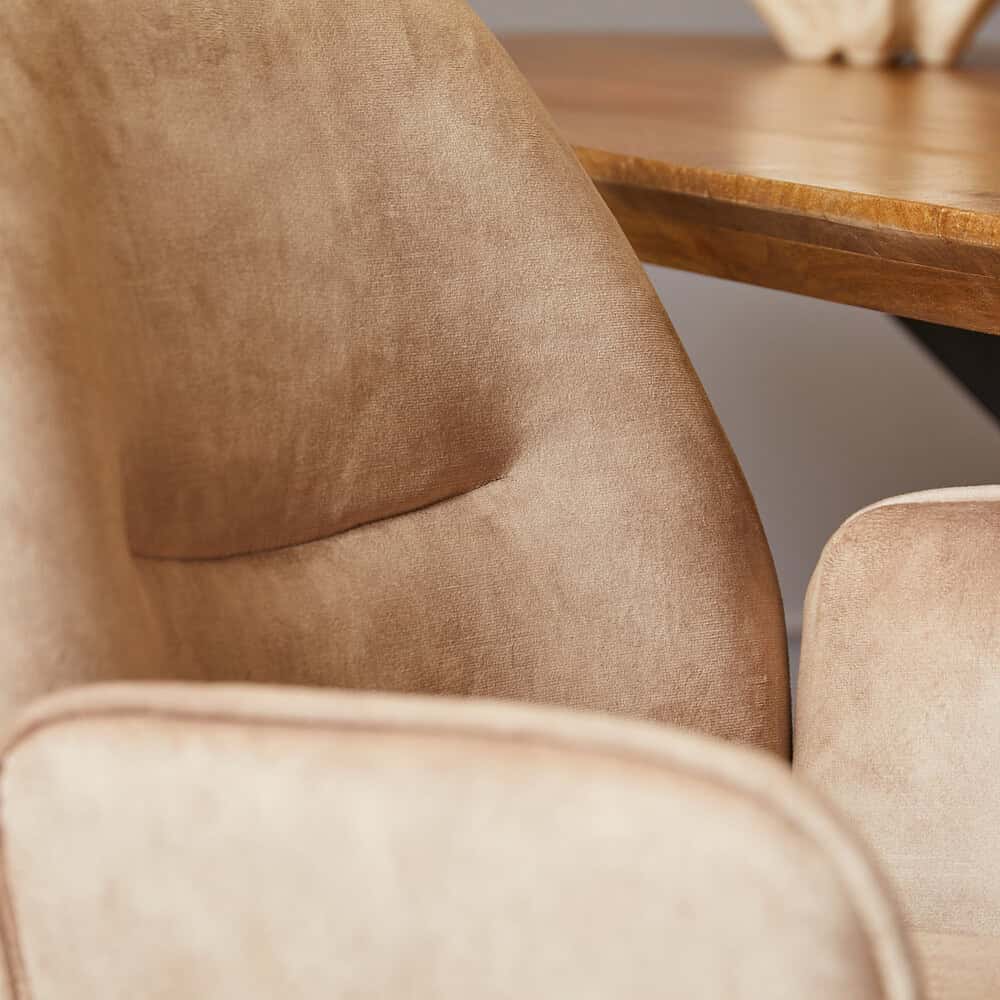 Luxe velvet eetkamerstoel met zacht beige bekleding, ontworpen door Mokana Meubelen voor stijlvol en comfortabel dineren.