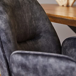 Gestructureerde close-up van een zwart velvet fauteuil met een houten tafel op de achtergrond, perfect voor interieur- en meubel SEO.