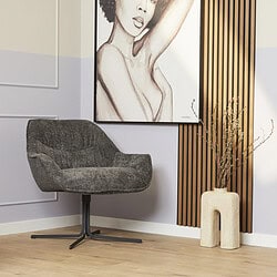 Modern vintage design fauteuil in grijs fluweel met zwart onderstel, geplaatst in een stijlvolle woonkamer met neutrale kleuren en mooie muurdecoratie, ideaal voor woon- en loungekamers.