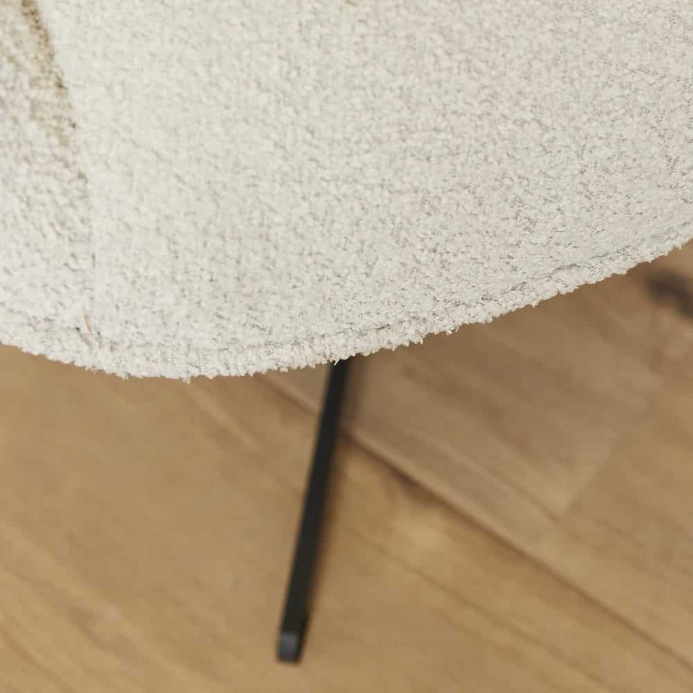 Modern zachte beige stoffering met zwarte metalen poot voor eigentijdse eetkamerstoel.