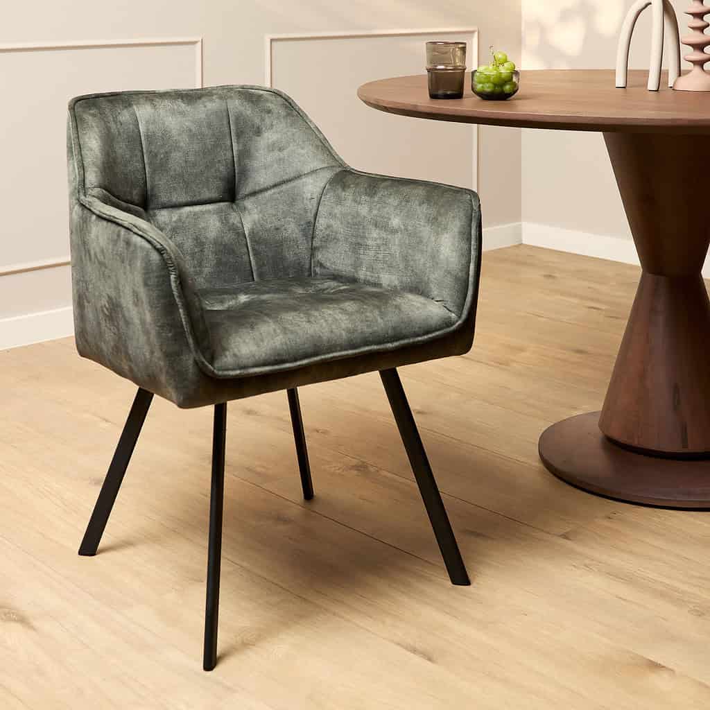 Vintage groen stoffen fauteuil met zwart metalen poten, stijlvol en comfortabel, perfect voor een moderne woonkamer of lounge.