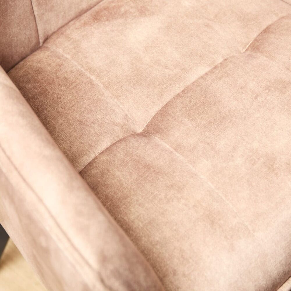 Luxe stoffen bank in een zachte, blush roze kleur met comfortabele kussens, perfect voor een gezellige woonkamer.