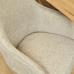 Elegant stofferen fauteuil met houten armleuning, ideaal voor modern en comfortabel interieur.