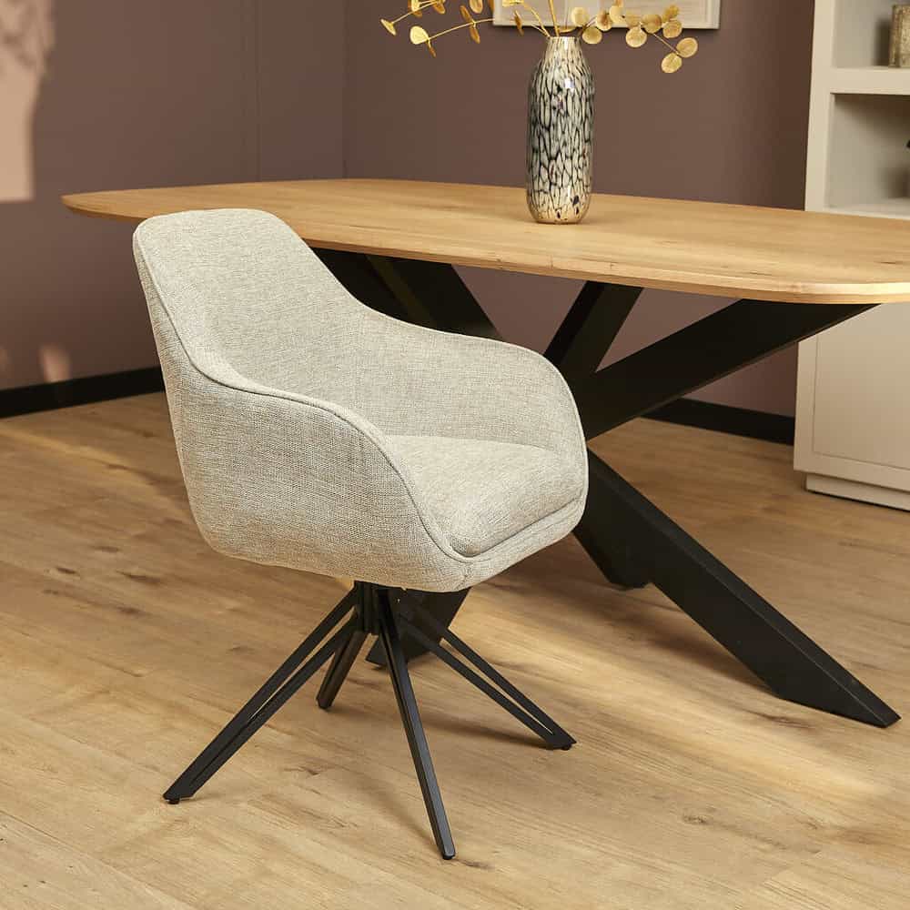 Licht beige eetkamerstoel met zwart metalen onderstel, comfortabele bekleding en moderne uitstraling, perfect voor een stijlvolle eethoek of kantoorruimte.