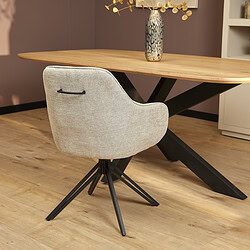 Modern eetkamerstoel met lichtbeige stoffen bekleding en zwart metalen poot onder een eikenhouten eettafel, stijlvol en comfortabel design.