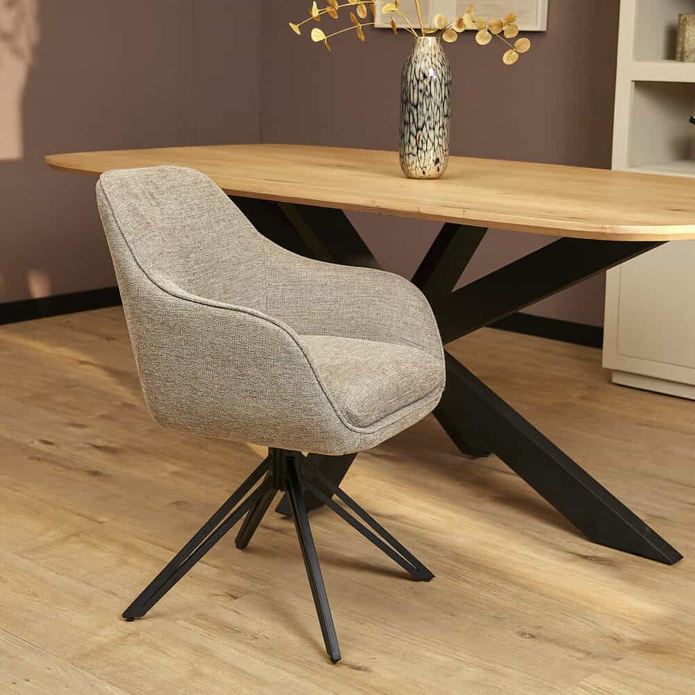 Houten eettafel met zwarte metalen poot, modern design en stijlvolle beige stofarmstoel met draaifunctie in een sfeervolle eetkamer. Perfect voor een gezellige en ruime eettafelset.