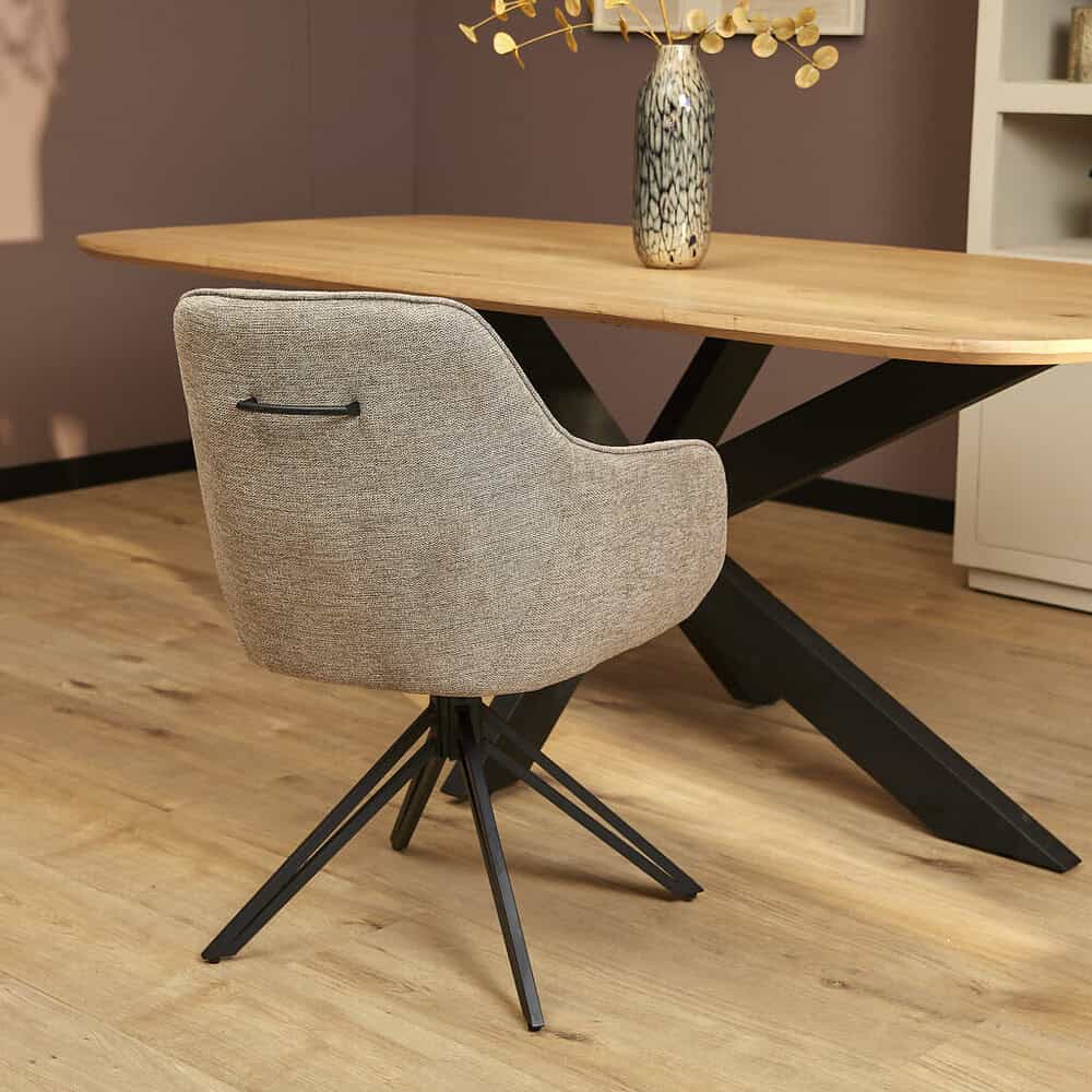 Elegant houten eettafel met stoer zwart metalen onderstel en stijlvolle stofarmstoel, perfect voor moderne eethoeken en interieuromgeving.