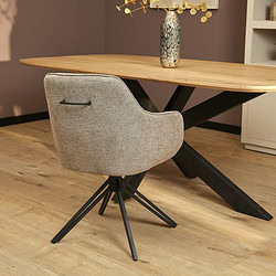 Elegant houten eettafel met stoer zwart metalen onderstel en stijlvolle stofarmstoel, perfect voor moderne eethoeken en interieuromgeving.