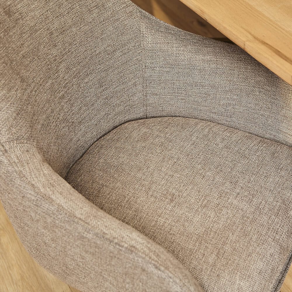 Stijlvolle fauteuil met zachte, effen stoffen bekleding en natuurlijke houten armleuningen, perfect voor een comfortabele zithoek in elk interieur.