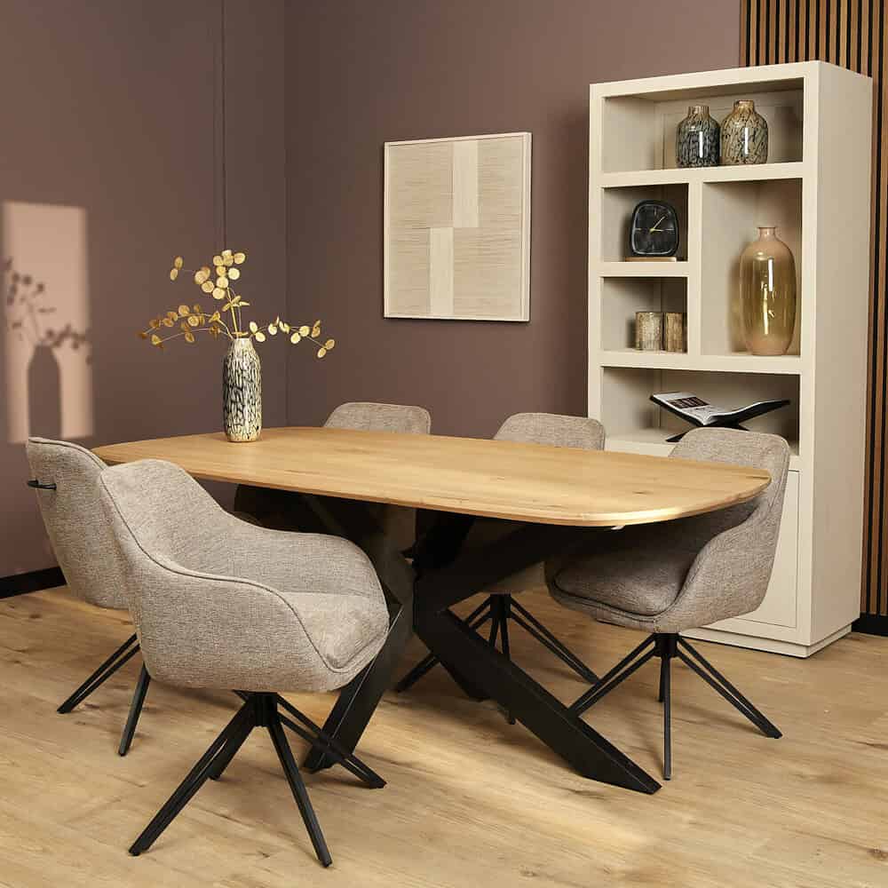Modern eettafel met fourkante poot en comfortabele stoffe stoelen, in een sfeervolle woonkamer met ronde vaas en decoratieve accessoires, perfect voor een stijlvolle eetruimte.