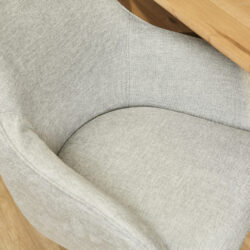 Luxueuze beige stof fauteuil met houten armleuningen voor een modern interieur.