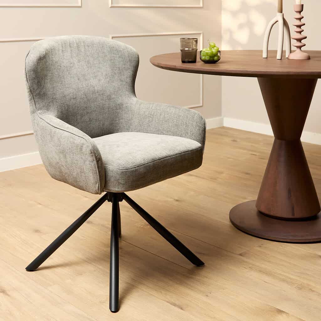 Modern eetkamerstoel met lichtgrijze bekleding en draaibare metalen pootjes, perfect voor een stijlvol interieur.