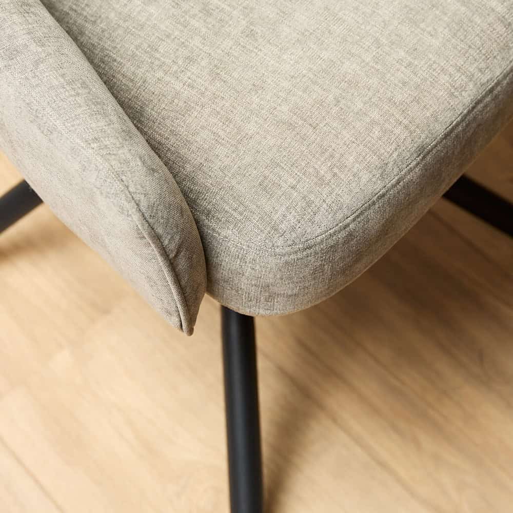 Mooi beige stoffen eetkamerstoel met zwarte metalen poten, moderne en comfortabele tuinmeubelen, hoogwaardige afwerking en elegant design, ideaal voor woon- of eetkamer interieurs.