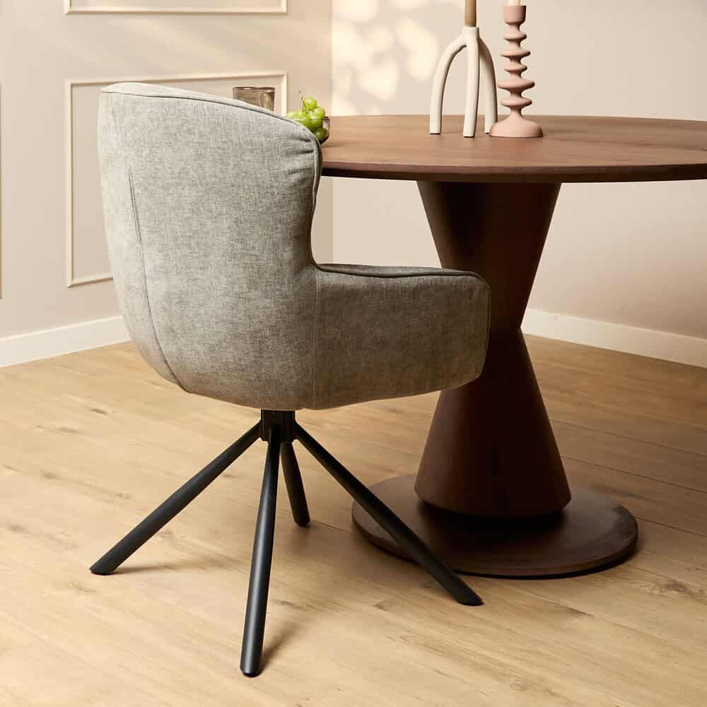 Moderne grijze armstoel met draaibaar onderstel, perfect voor eetkamer of kantoor, gecombineerd met houten tafel en stijlvolle decoratie.