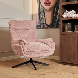 Zachte roze fauteuil met draaibaar onderstel in een modern interieur met kunstwerk en houten kast.