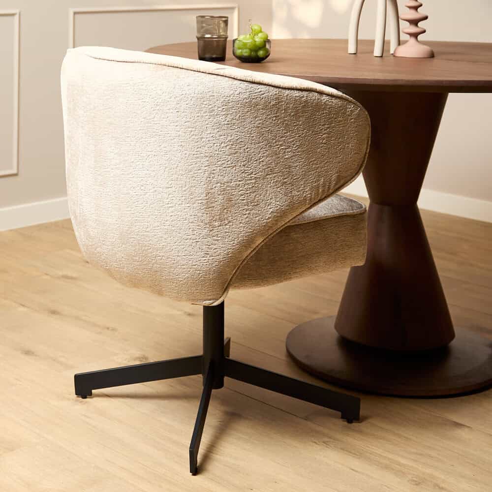 Elegante beige gestoffeerde eetkamerstoel met zwart metalen poot, perfect voor moderne interieurs. Ontworpen door Mokana Meubelen voor stijlvolle eetruimtes.