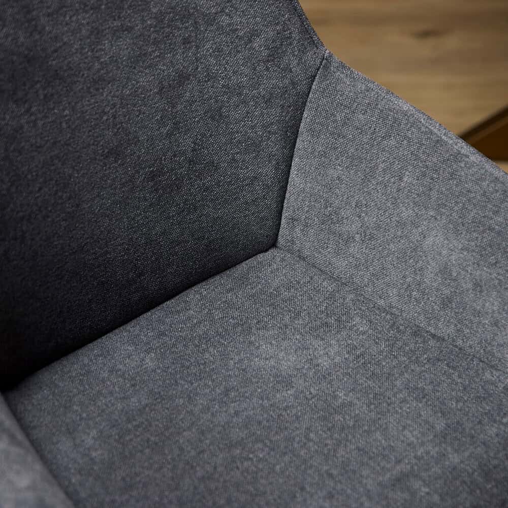 Hoge resolutie close-up van een moderne, zitbank met donkergrijze stoffering, perfect voor een eigentijdse woonkamer of kantooromgeving.