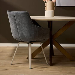 Donkere velvet eetkamerstoel met metalen poten naast een houten eettafel. Moderne, comfortabele stoel voor eetkamer of kantoor met elegant design en luxe uitstraling. Perfect voor modern interieur.