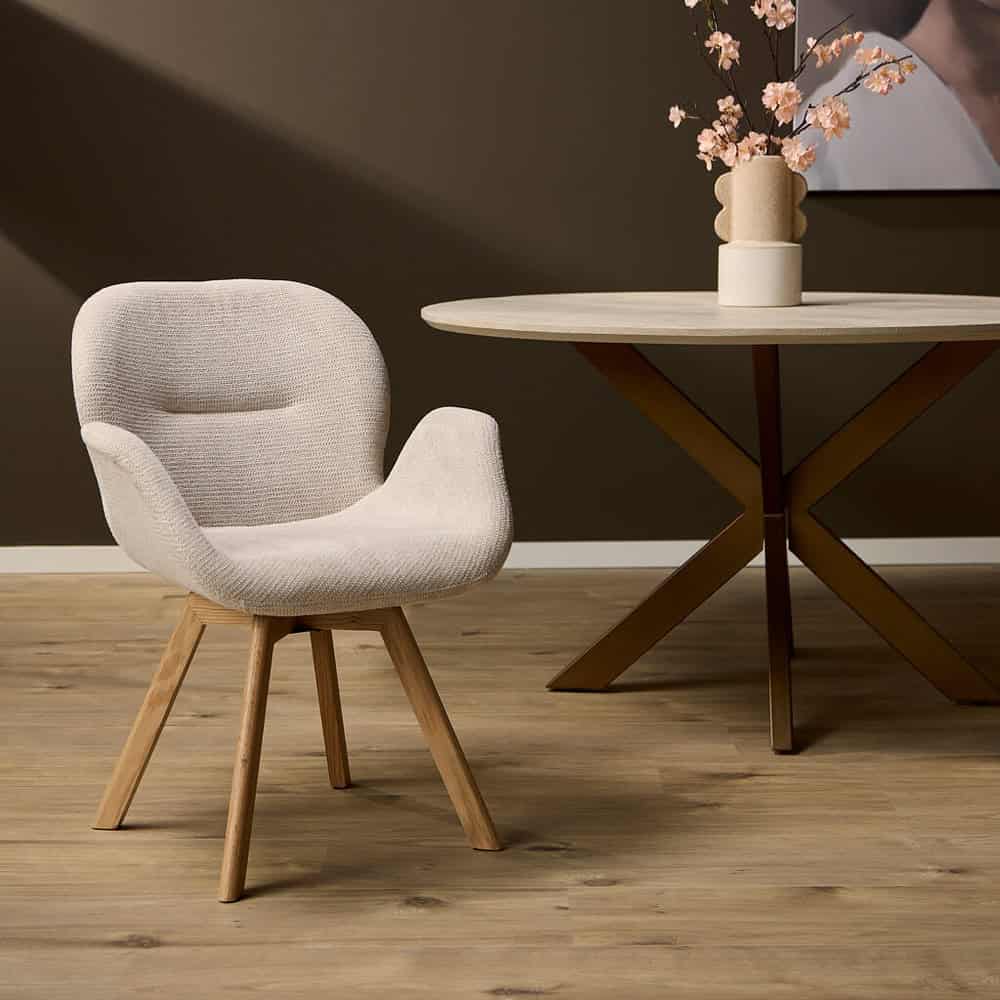 Moderne Scandinavische armstoel met houten poten en zachte beige bekleding, perfect voor een stijlvol interieur.
