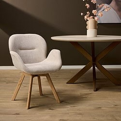 Moderne Scandinavische armstoel met houten poten en zachte beige bekleding, perfect voor een stijlvol interieur.