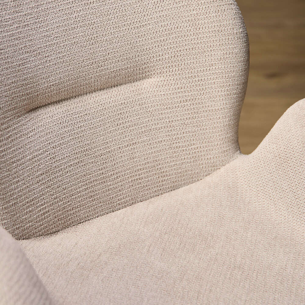 Zacht beige stoffen fauteuil met comfortabele bekleding en elegante vormgeving, ideaal voor een stijlvolle woonkamer.