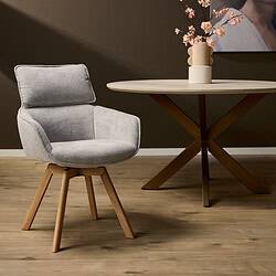 Elegante houten stoel met comfortabel lichtgrijs gestoffeerd zitvlak en rugleuning, gecombineerd met een luxe eettafel en decoratieve bloemenvase in een modern interieur.