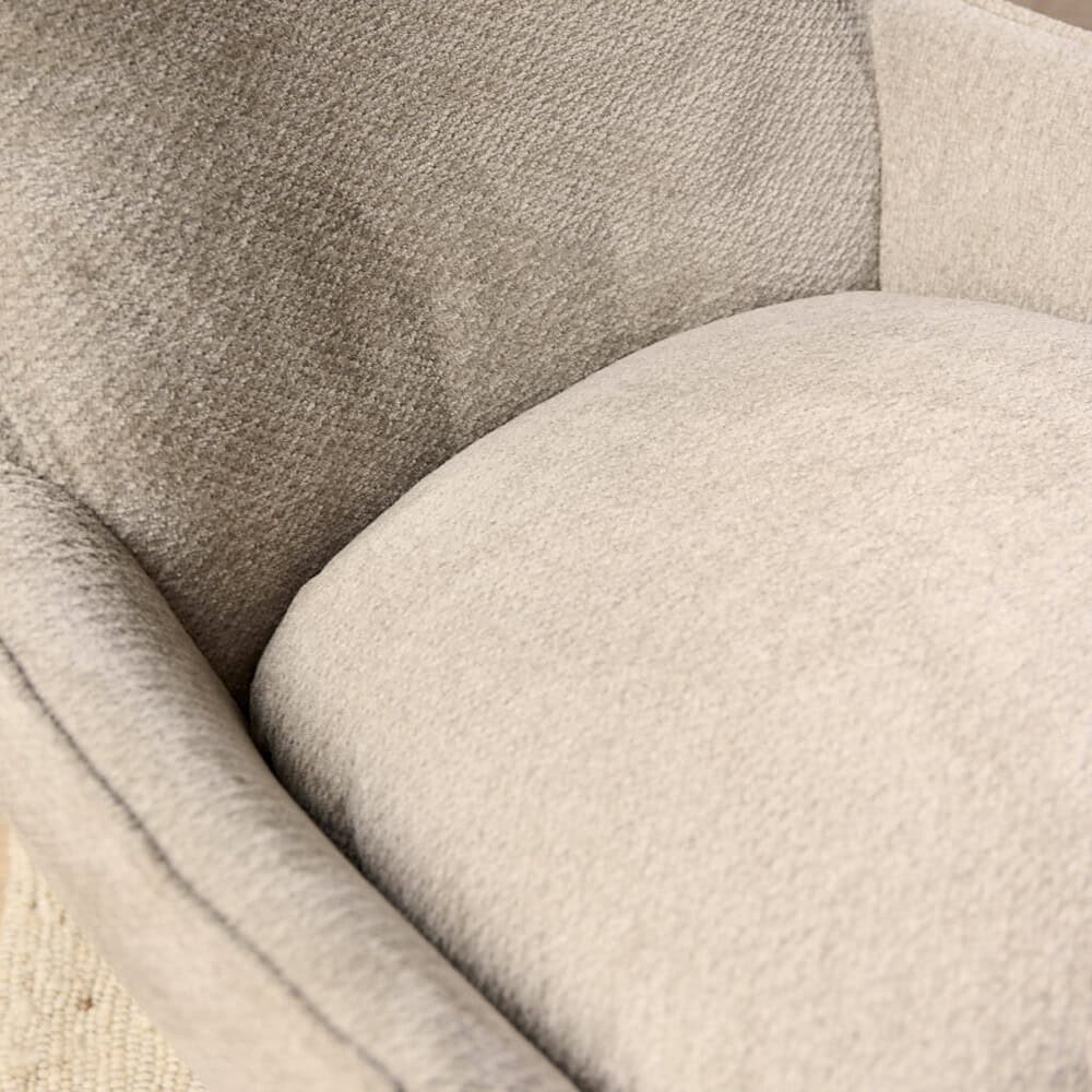 Zacht beige stoffen fauteuil met een comfortabele zitting en rugleuning, perfect voor een luxe en gezellige woonruimte.
