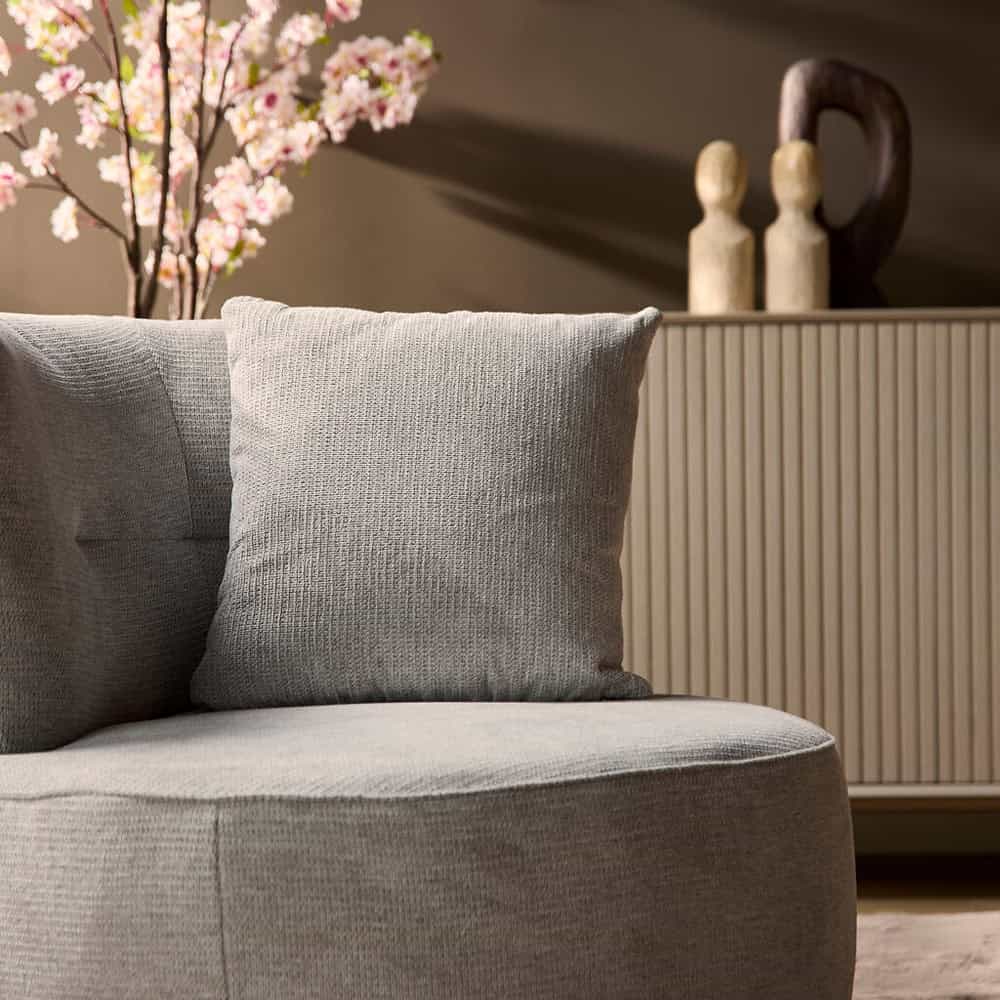 Elegant woonkamerset met comfortabele lichtgrijze stoffering en stijlvolle decoratieve accessoires, perfect voor een modern interieur.