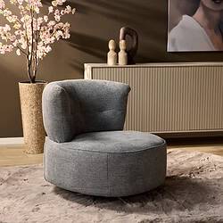 Relaxfauteuil in moderne woonkamer met houten vloer en beige wand, gecombineerd met vintage accessoires en een bloeiende kersenboom, perfect voor stijlvolle en comfortabele meubelbeleving.