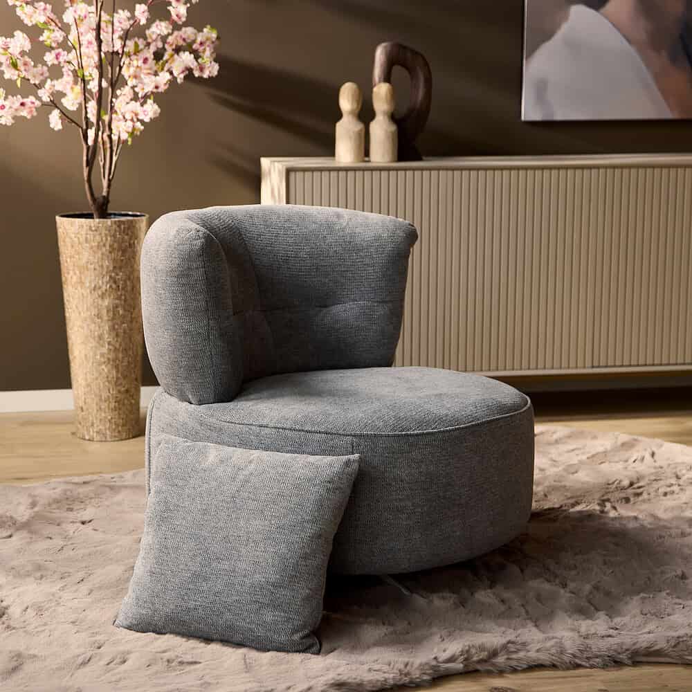 Zachte grijze fauteuil met bijpassend sierkussen, modern en comfortabel design, perfect voor een stijlvolle woonkamer inrichting.
