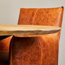 Vintage leren eetkamerstoel met houten tafelblad, hoogwaardige meubelstukken, perfect voor een stijlvolle en comfortabele eetruimte. Op maat gemaakte meubels van Mokana Meubelen voor uw interieur.