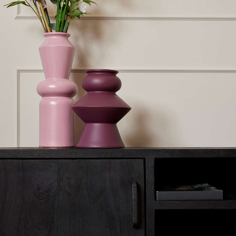 Een zwarte houtentafelel met twee sierlijke vazen in roze en bordeaux, decoratief en modern interieur, Mokana Meubelen.