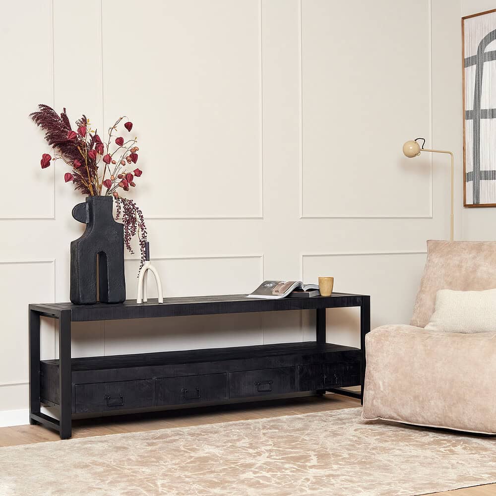 Voorkant van een houten salontafel met lades in een modern interieur, decoratief vaartuig en planten op de tafel, beige bank en muur met wandlamp en kunstwerk, stijlvolle meubels, Mokana Meubelen.