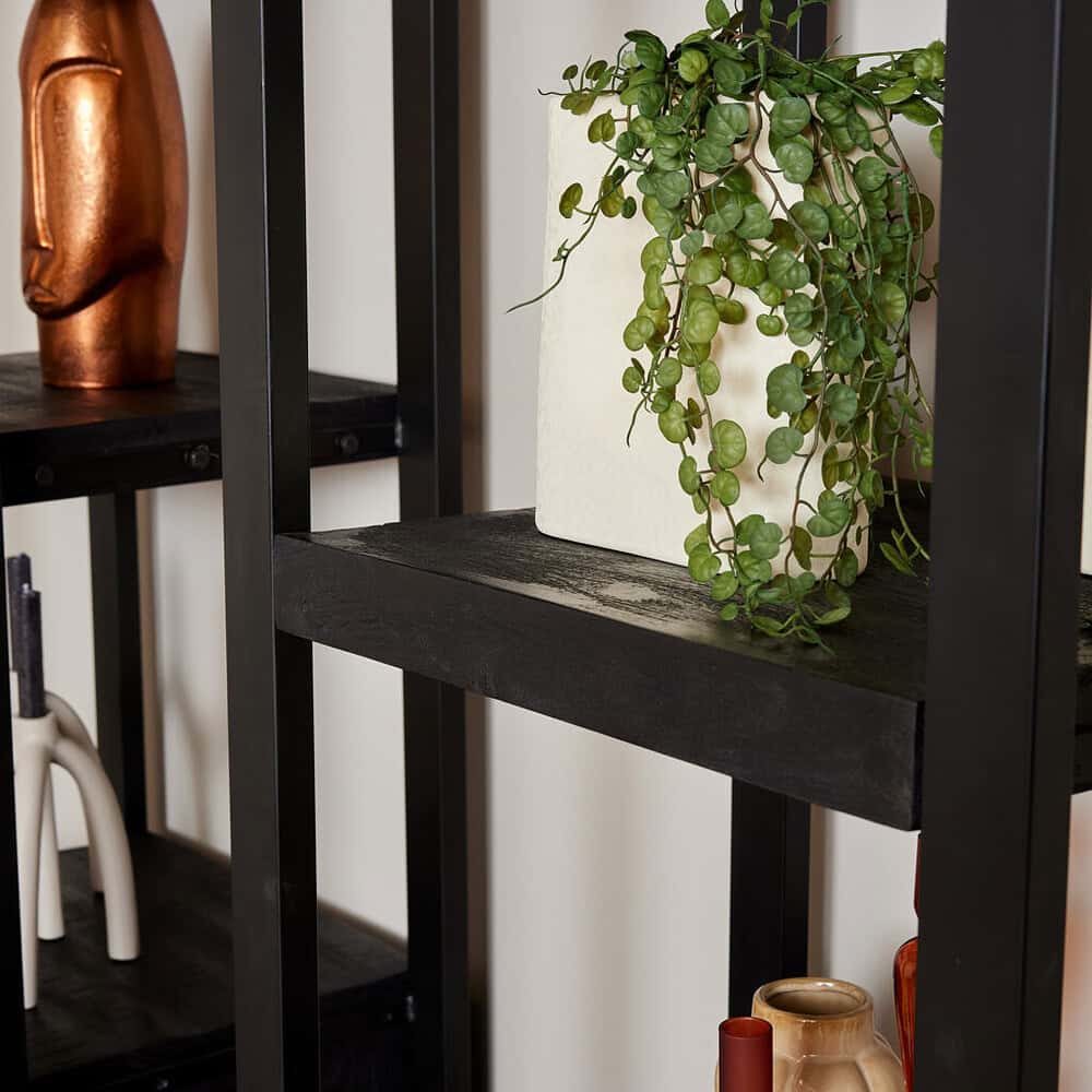 Natursteen plantenbak met groenevaren op zwart metalen boekenkast voor modern interieur.