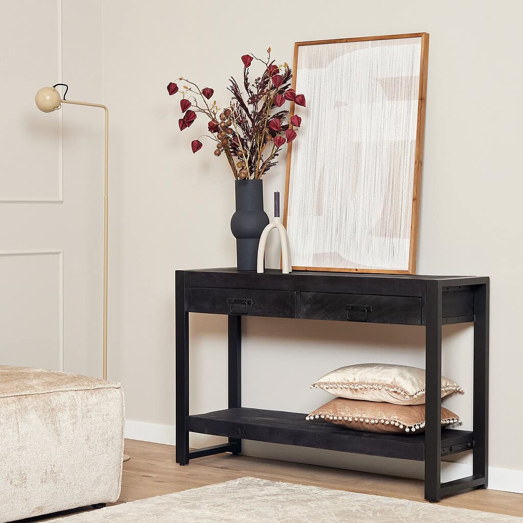Modern zwart houten console tafel met opbergplanken en decoratieve accessoires in een lichte, stijlvolle woonkamer.