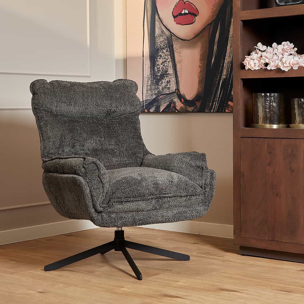 Lichtgrijze vintage draaibare fauteuil met comfortabele bekleding en moderne zwart metalen onderstel, passend in elk modern interieur, ideaal als stijlvolle en relaxte zithoek.