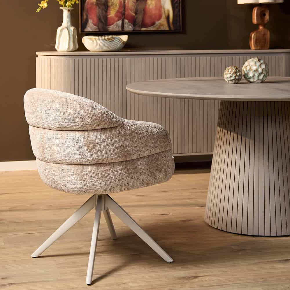Zachte beige stof fauteuil met modern ontwerp op houten vloer, stijlvol interieur met decoratieve accessoires en meubelstukken van Mokana Meubelen.