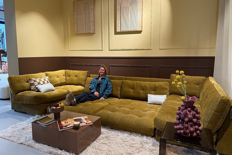 Luxe groene hoekbank van Mokana Meubelen in een stijlvolle showroom.