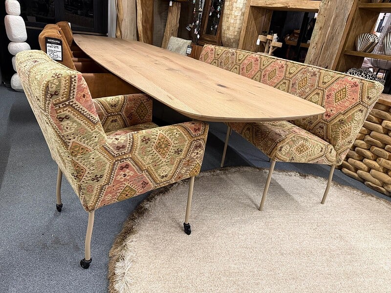 Vintage houten eettafel met kleurrijke stoffen stoelen en bank, perfecte meubels voor een stijlvolle en gezellige eetruimte, Mokana Meubelen.