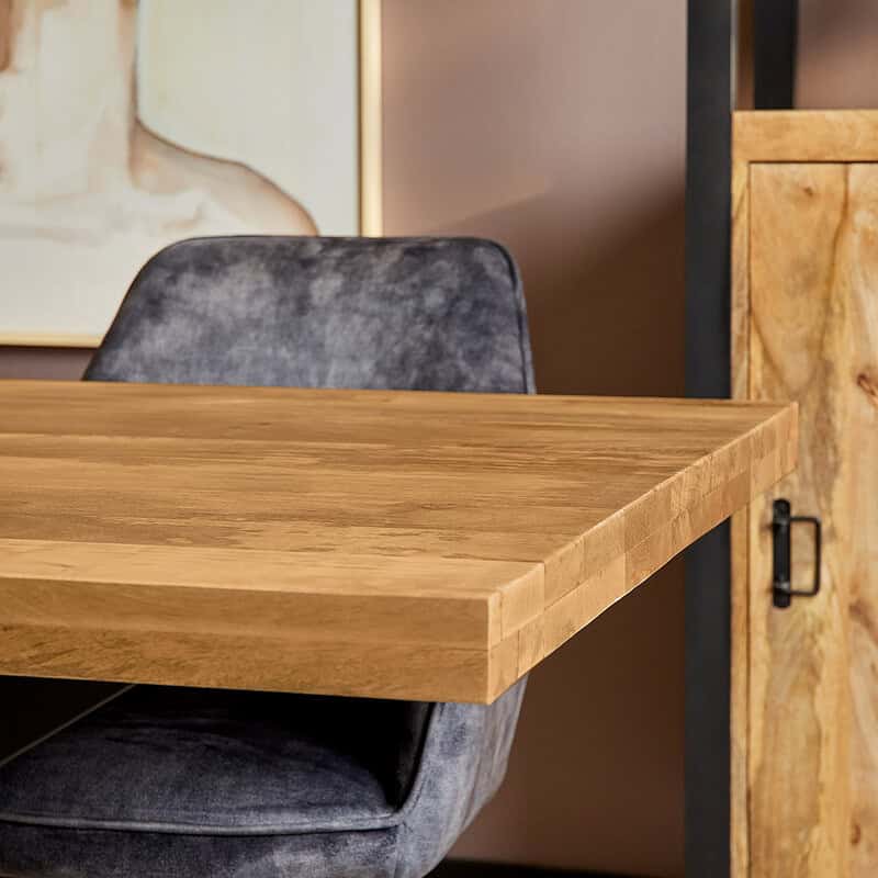 Elegante houten tafel gecombineerd met een moderne stoffen stoel, perfect voor een stijlvolle eethoek of werkomgeving. Ambachtelijke meubelstukken met hoogwaardige afwerking van Mokana Meubelen.