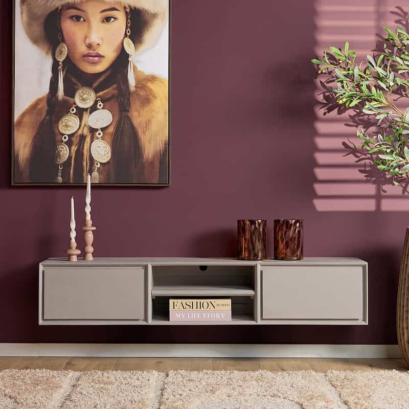 Elegante, moderne witte wandmeubel met opbergruimte, decoratieve accessoires en een grote kunstafdruk aan een warmpaarse muur voor stijlvolle woondecoratie.