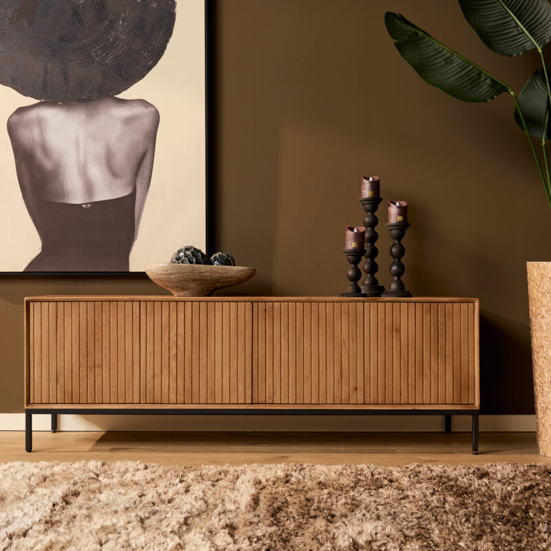 Strak houten dressoir met zwarte metalen poten, modern design, perfect voor woonkamer, met decoratieve kandelaars, kunstwerk en planten in interieur | Mokana Meubelen.