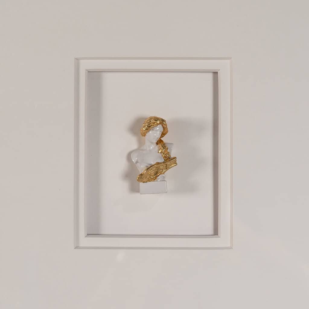 Elegante sieradenstandaard in een wit frame met gouden en witte sculptuur als decoratief stuk, ideaal voor een stijlvolle woonkamer of slaapkamer.